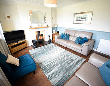Self Catering Accommodation in Dornie living room with woodburning stove electric recliner seats and Smart TV with Freeview