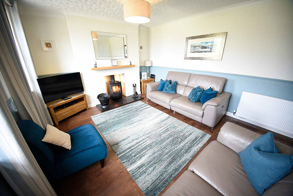 Self Catering Accommodation in Dornie living room with woodburning stove electric recliner seats and Smart TV with Freeview
