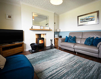 Relax in Glas Eilean View Self Catering Accommodatio living room with woodburning stove and electric recliner seating