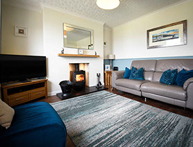 Relax in Glas Eilean View Self Catering Accommodatio living room with woodburning stove and electric recliner seating