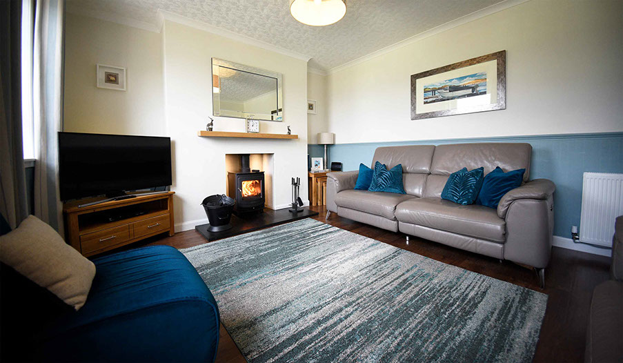 Relax in Glas Eilean View Self Catering Accommodatio living room with woodburning stove and electric recliner seating